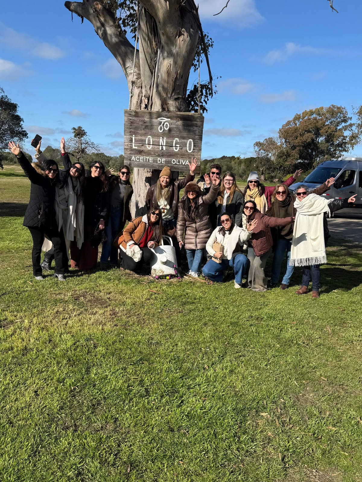 Grupo junto al cartel de aceite de oliva